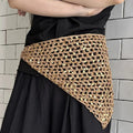 Foulard triangolare beige con motivo a rete traforata e paillettes, indossato sopra una gonna nera