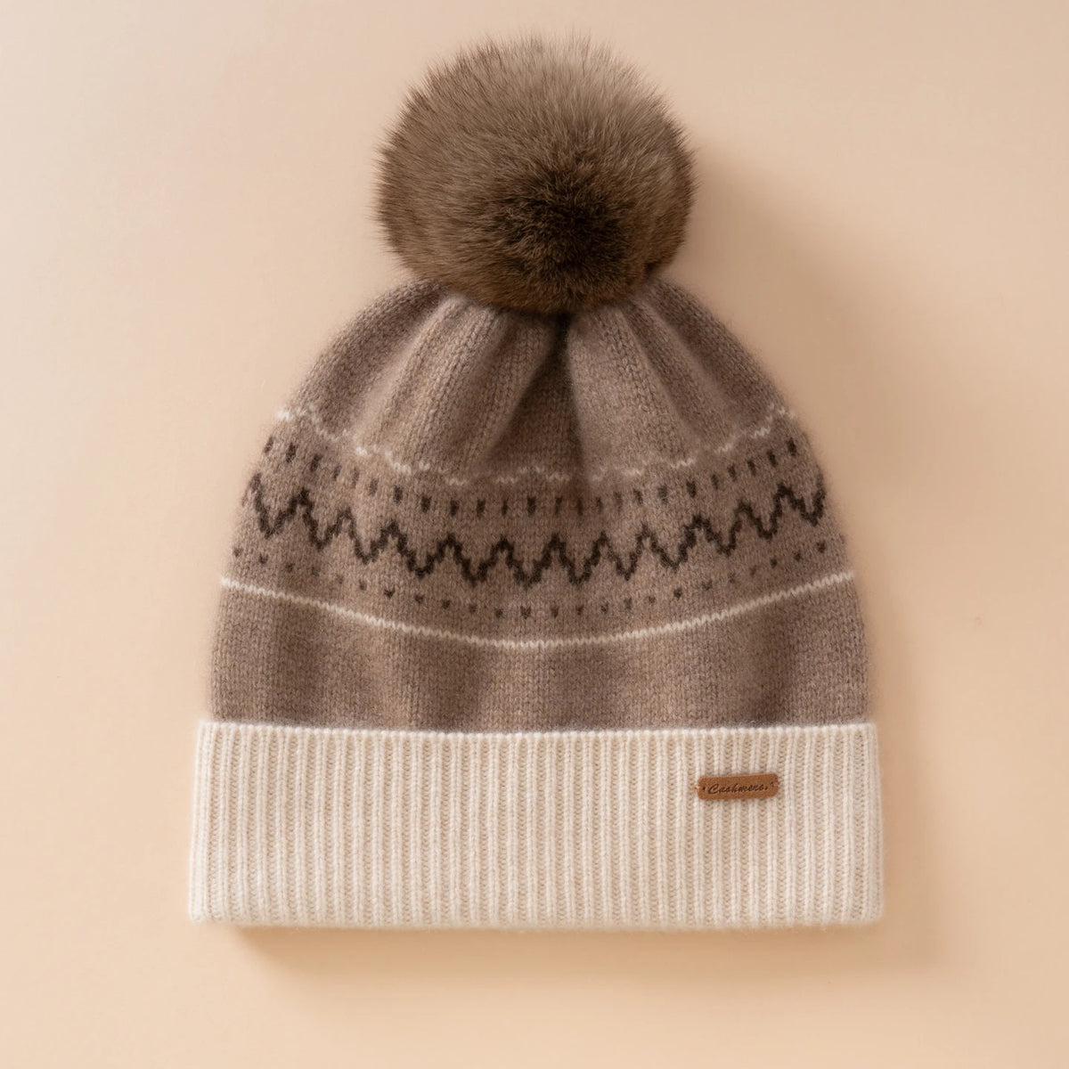 Berretto color tortora con motivo nordico, risvolto bianco panna a coste e pompon nella tonalità marrone
