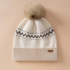 Berretto in cashmere con motivo jacquard nordico a fasce geometriche e pompon in pelliccia di coniglio