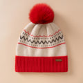 Berretto color crema con motivo nordico, risvolto rosso a coste e grande pompon dello stesso rosso