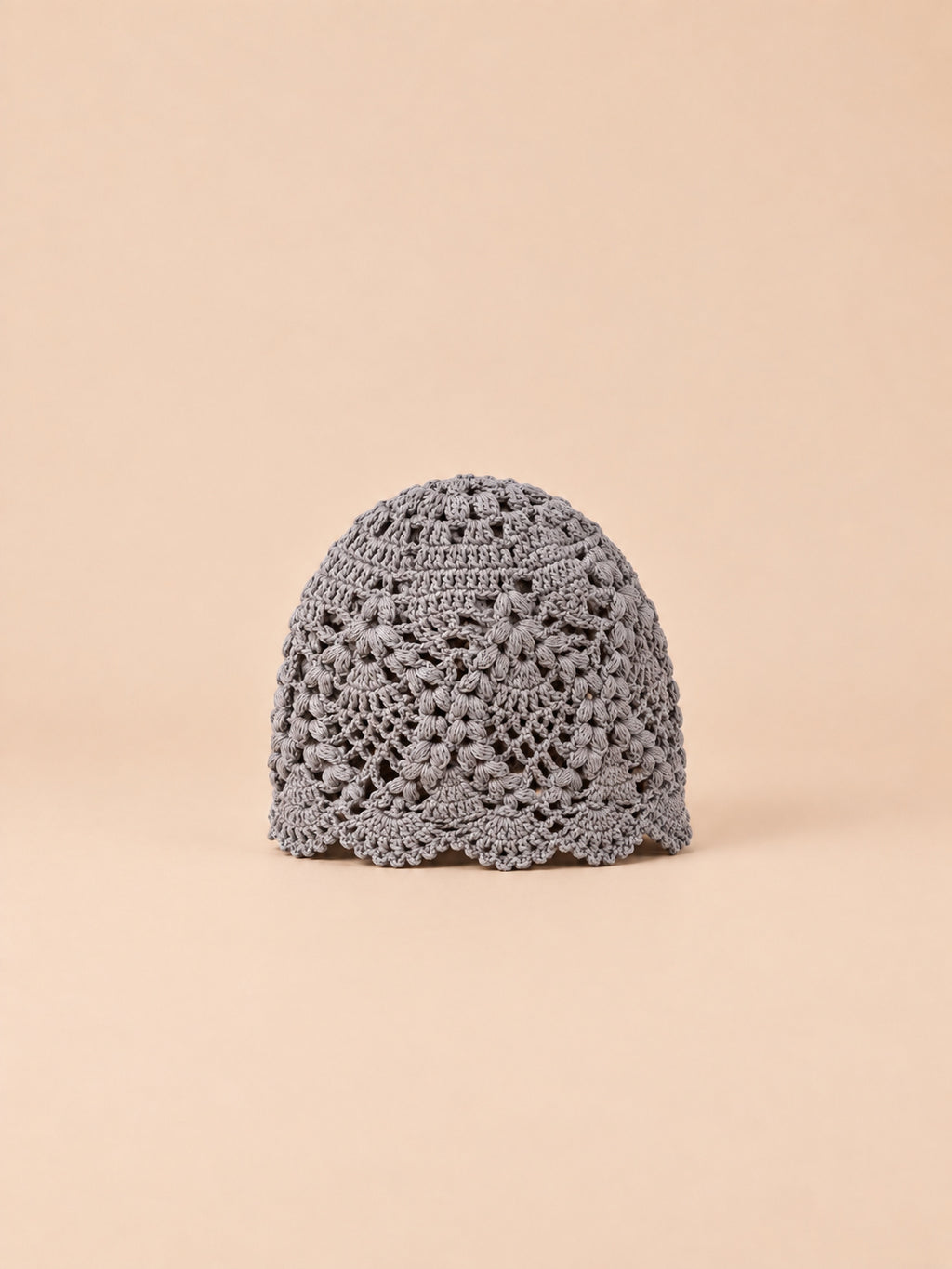 Cappello estivo grigio in pizzo floreale con motivo traforato a fiori e bordo ondulato, vista frontale