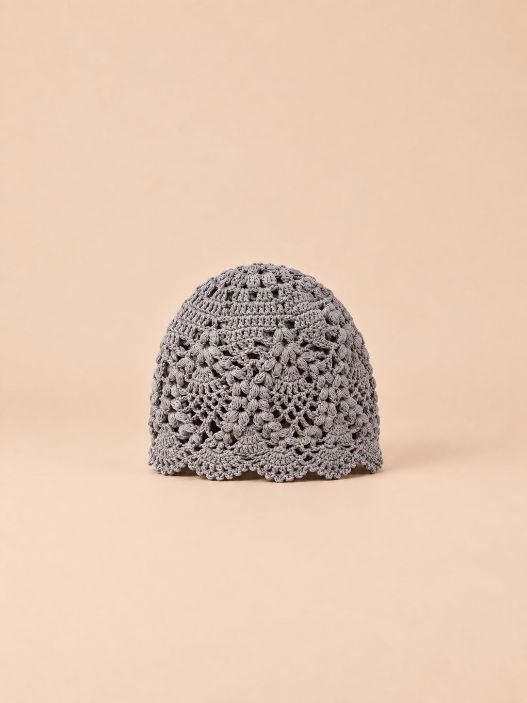 Cappello estivo grigio in pizzo floreale con motivo traforato a fiori e bordo ondulato, vista frontale