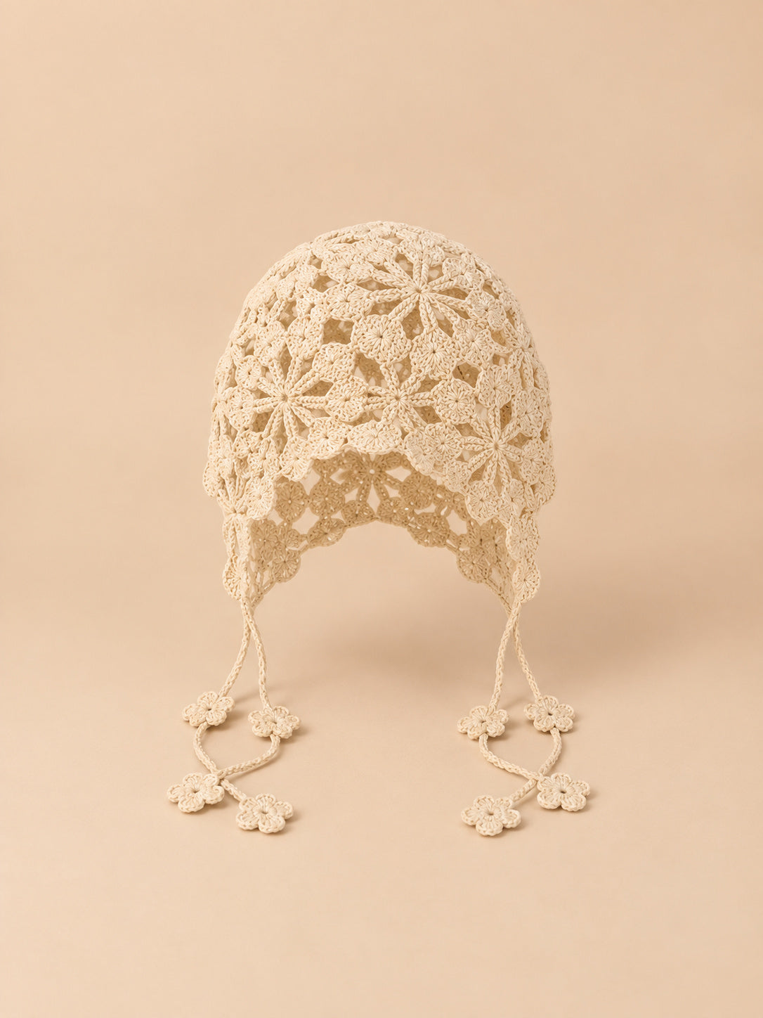 Cappello beige a rete traforata da annodare, con lacci per regolare la vestibilità, visto di fronte