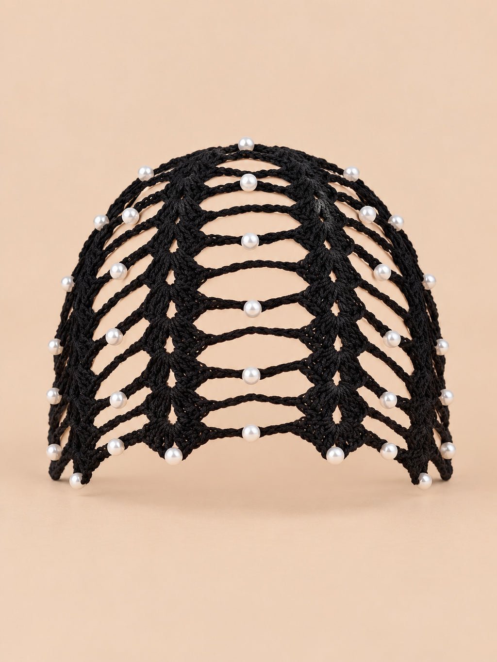 Bandana da donna nera con perline in stile bohémien, vista frontale su sfondo color sabbia e pesca