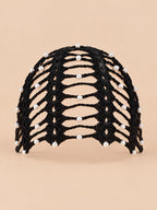 Bandana da donna nera con perline in stile bohémien, vista frontale su sfondo color sabbia e pesca