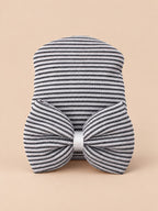 Cappellino da neonata in cotone a righe con grande fiocco, colori nero e bianco, vista frontale