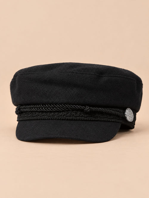 Cappello da marinaio nero a otto spicchi con visiera, stile capitano, su sfondo color sabbia e pesca