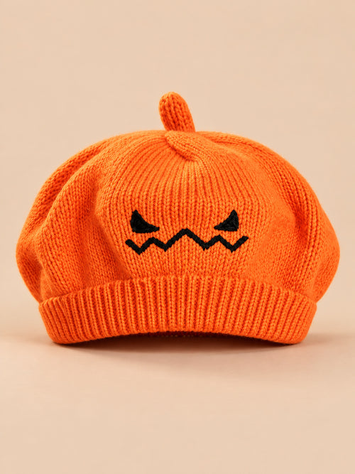 Basco arancione da bambino in maglia con viso di zucca ricamato per Halloween, fotografato di fronte