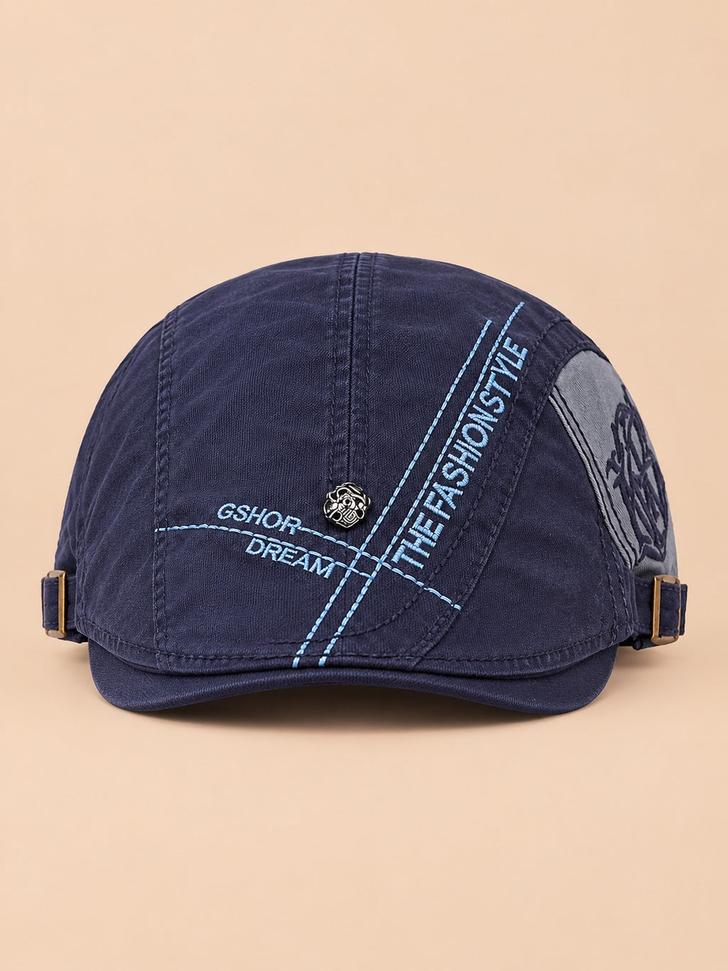 Cappello gavroche piatto blu navy in cotone per tutte le stagioni, su sfondo color sabbia e pesca