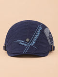 Cappello gavroche piatto blu navy in cotone per tutte le stagioni, su sfondo color sabbia e pesca