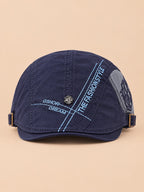 Cappello gavroche piatto blu navy in cotone per tutte le stagioni, su sfondo color sabbia e pesca