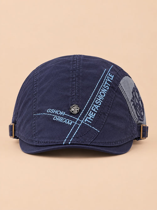 Cappello gavroche piatto blu navy in cotone per tutte le stagioni, su sfondo color sabbia e pesca