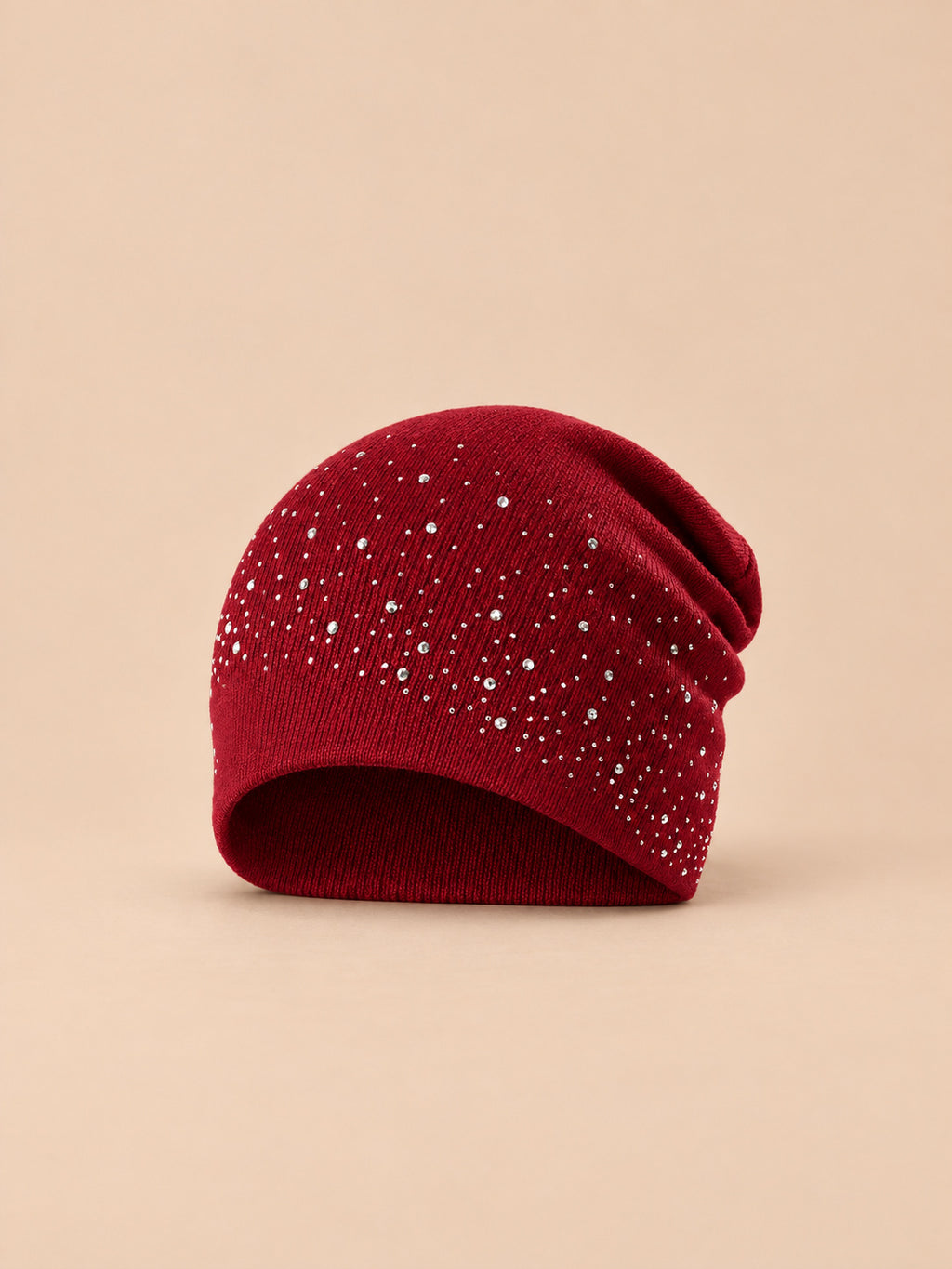Berretto bordeaux da donna in maglia con strass, stile streetwear, su sfondo color sabbia e pesca