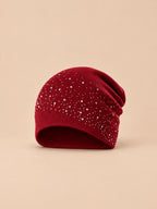 Berretto bordeaux da donna in maglia con strass, stile streetwear, su sfondo color sabbia e pesca