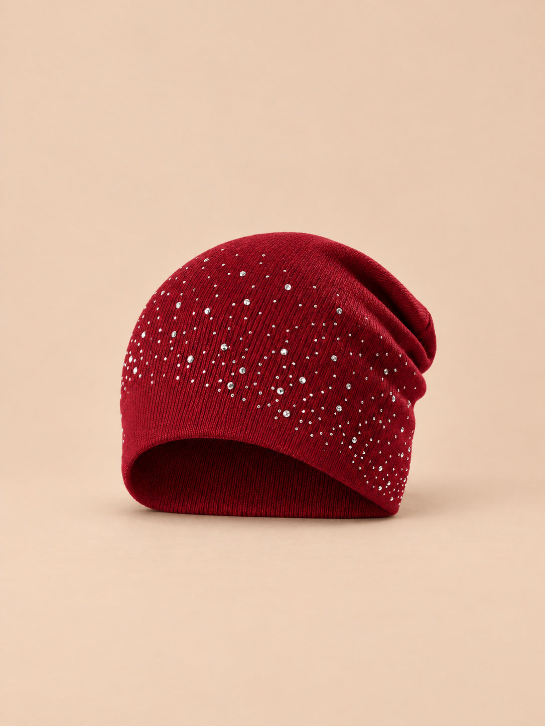 Berretto bordeaux da donna in maglia con strass, stile streetwear, su sfondo color sabbia e pesca