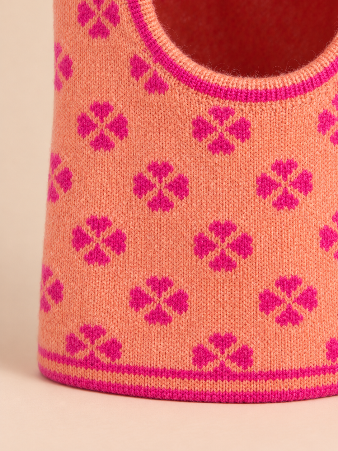Dettaglio della maglia arancione rosata con trifogli jacquard rosa del passamontagna da donna