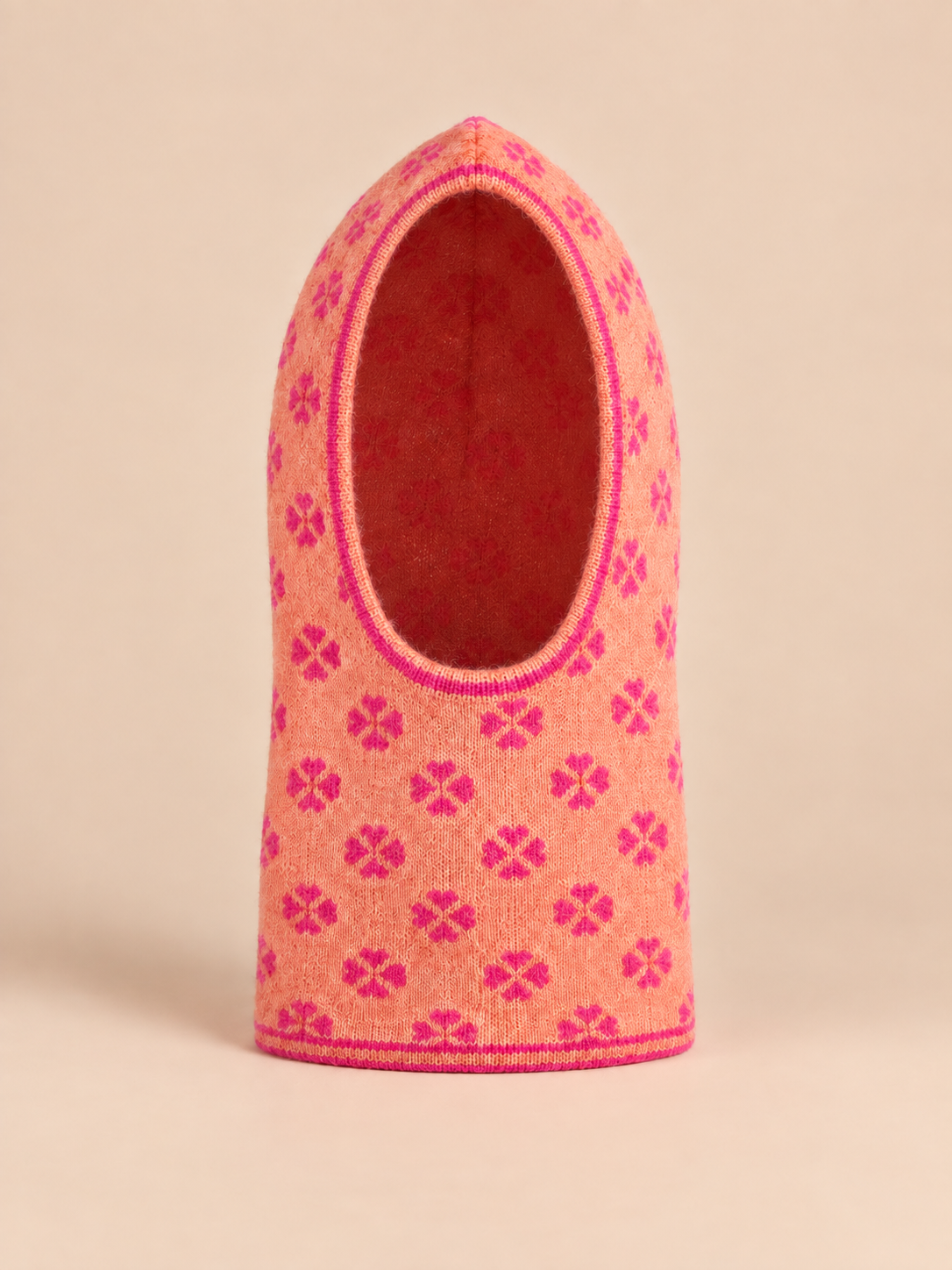 Passamontagna da donna in maglia jacquard con trifogli, color arancione rosato, fotografato di fronte