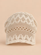 Cappello a calotta beige a rete arricciata, in stile coreano, vista frontale su sfondo sabbia e pesca