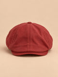 Cappello piatto rosso con visiera corta, in stile britannico vintage, fotografato nella vista frontale