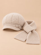 Set da donna beige composto da cappello soffice e sciarpa lavorata a maglia, fotografato di fronte