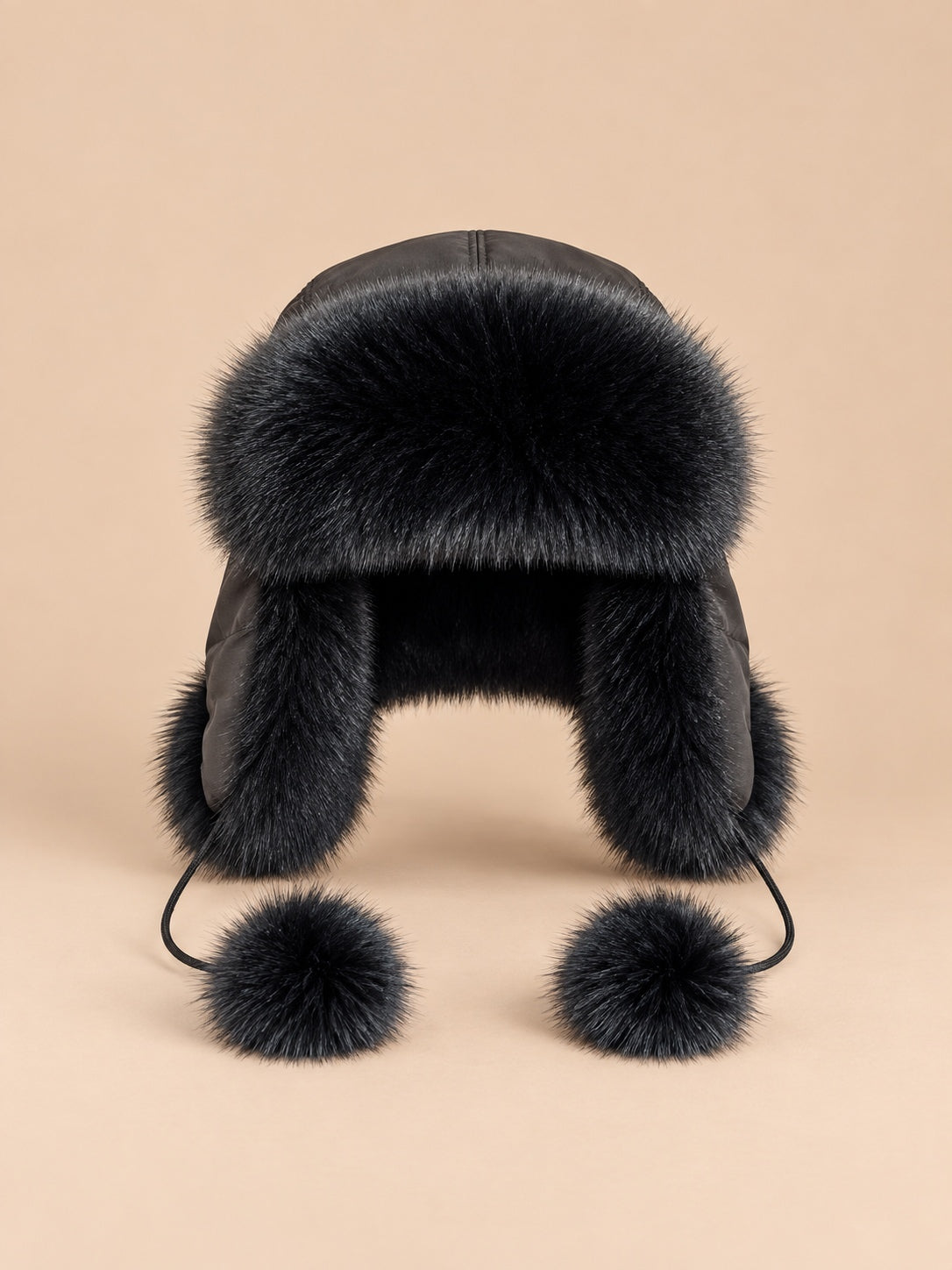 Colbacco nero da donna in pelliccia di volpe con pompon decorativi e paraorecchie, visto di fronte
