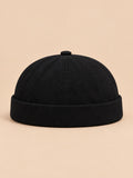 Berretto docker nero in denim con risvolto e cinturino regolabile, stile workwear, fotografato di fronte