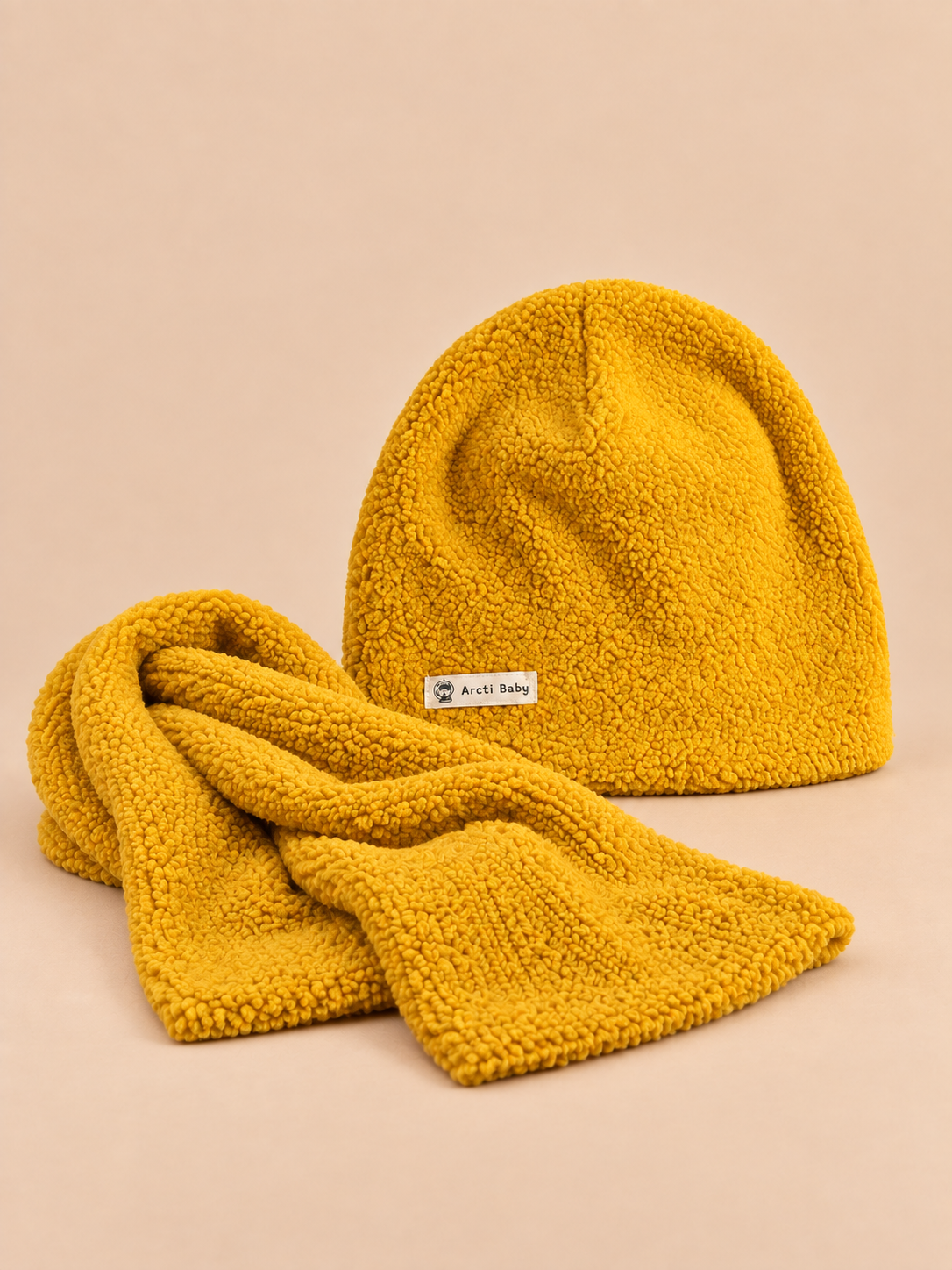 Set giallo da bambino effetto peluche, con berretto e sciarpa coordinati nei colori, visto di fronte