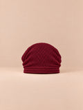 Berretto oversize in maglia caldo e antivento, colore rosso, vista frontale, su sfondo color sabbia e pesca
