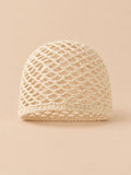 Cappello estivo leggero da donna in rete di cotone beige, visto di fronte su sfondo sabbia e pesca