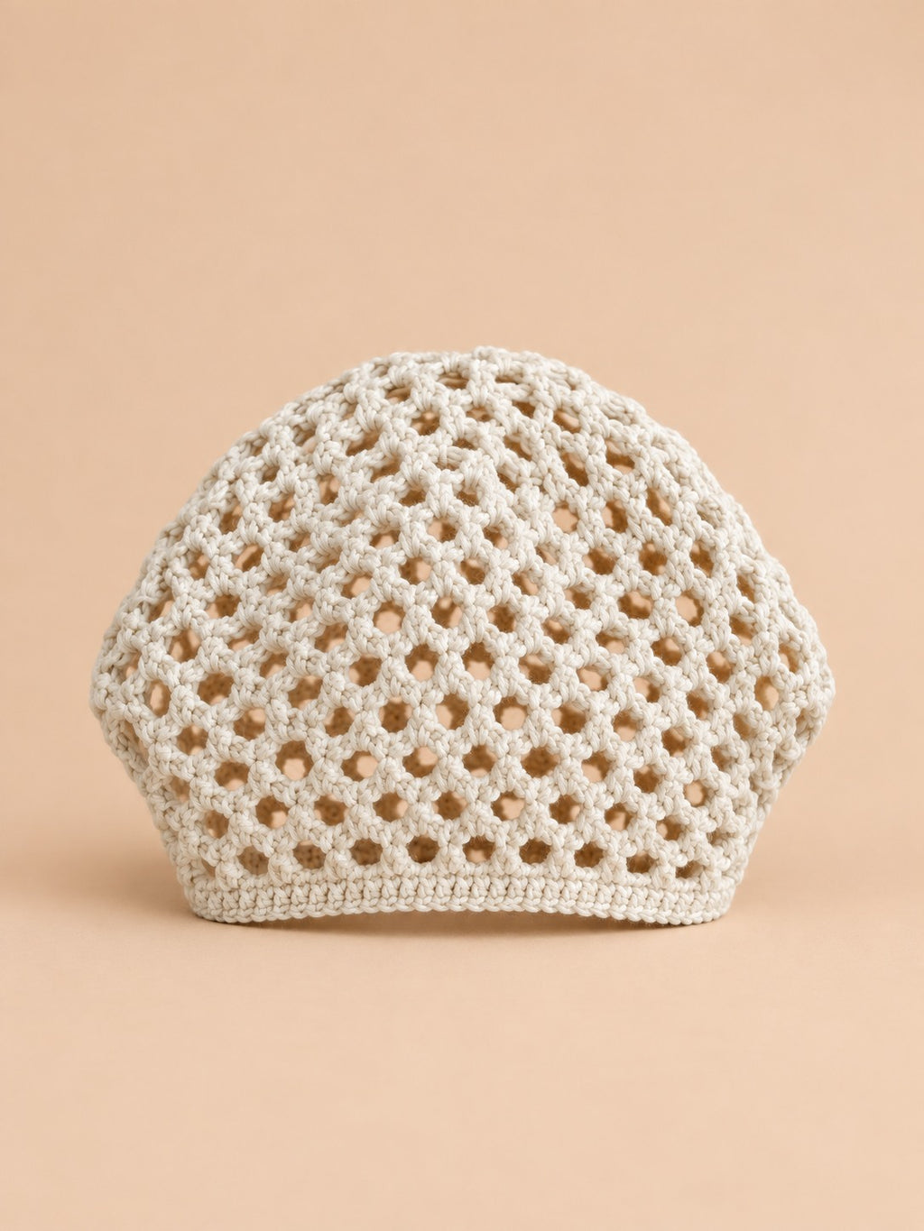 Cappello beige a rete con motivo fine a coste e struttura ariosa in stile rétro, visto di fronte