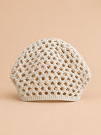 Cappello beige a rete con motivo fine a coste e struttura ariosa in stile rétro, visto di fronte