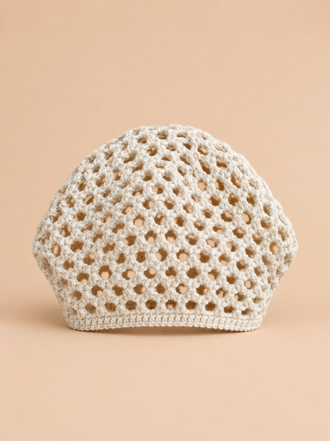 Cappello beige a rete con motivo fine a coste e struttura ariosa in stile rétro, visto di fronte