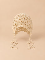 Cappello estivo beige senza tesa, aderente alla testa, con fiori traforati in stile bohémien, vista frontale