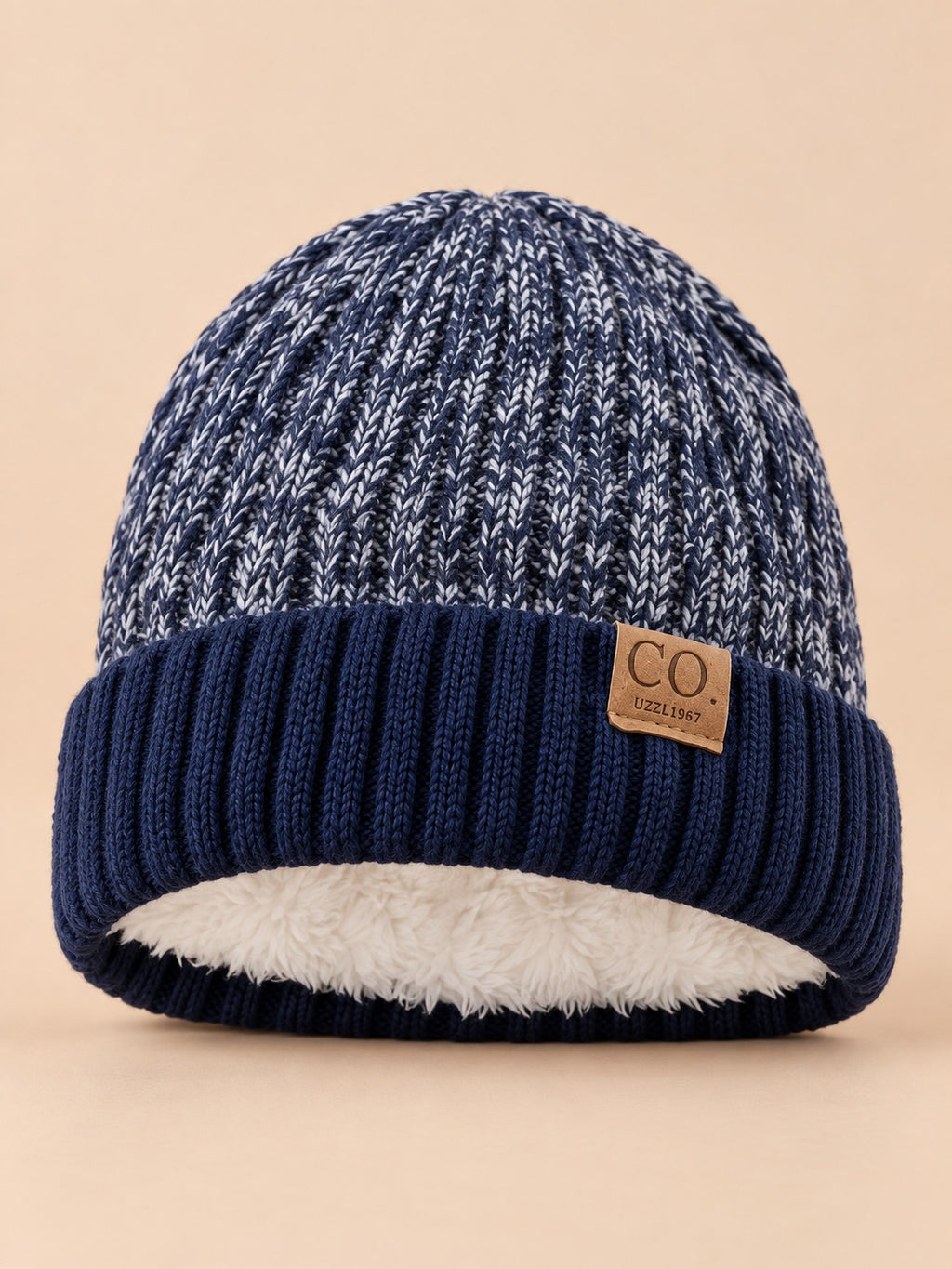 Berretto da sci blu navy, caldo e confortevole, con fodera interna, visto di fronte su sfondo beige