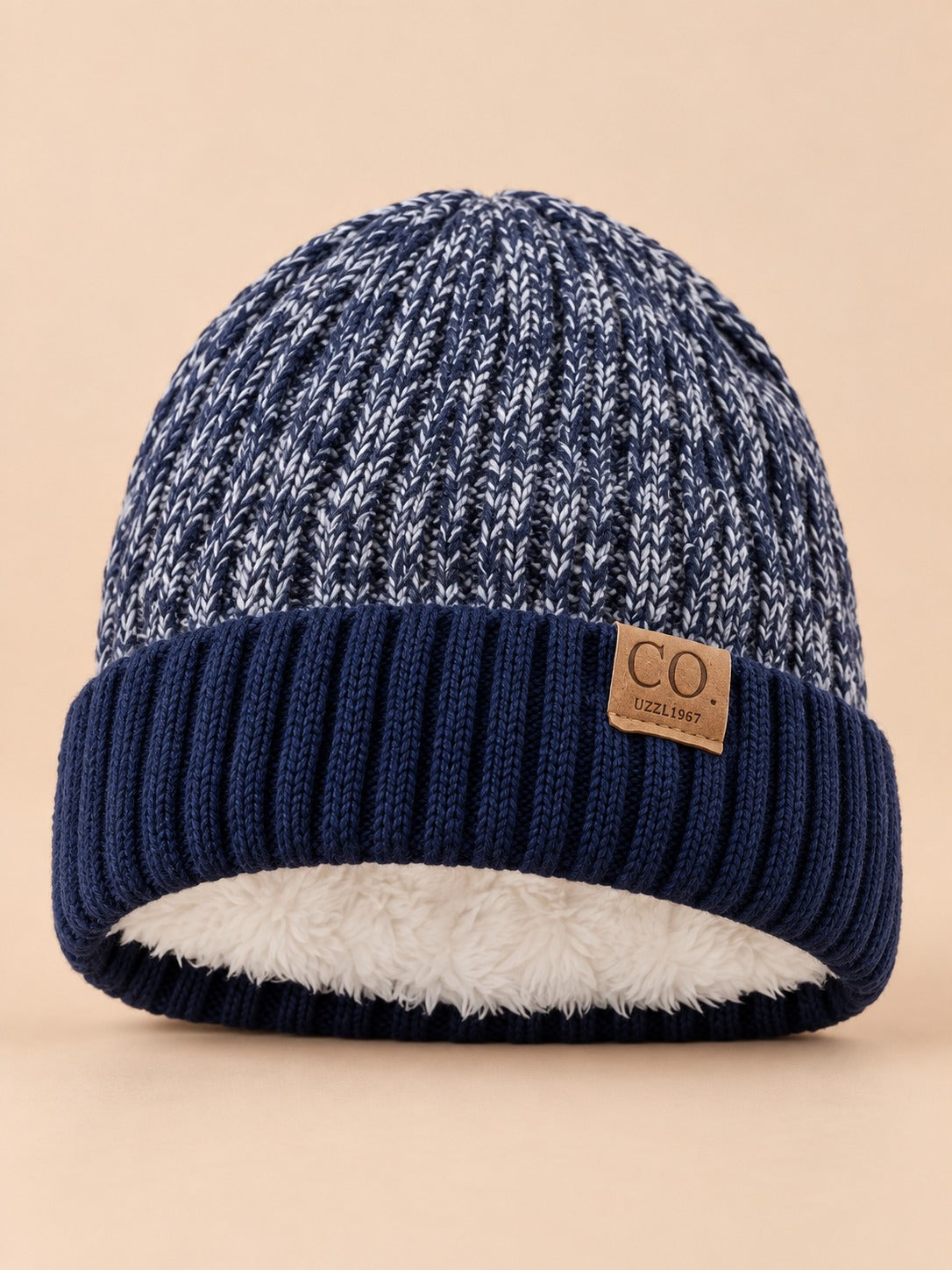 Berretto da sci blu navy, caldo e confortevole, con fodera interna, visto di fronte su sfondo beige