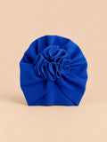 Turbante blu da neonato con fiore decorativo in tessuto sul davanti e forma morbida, vista frontale