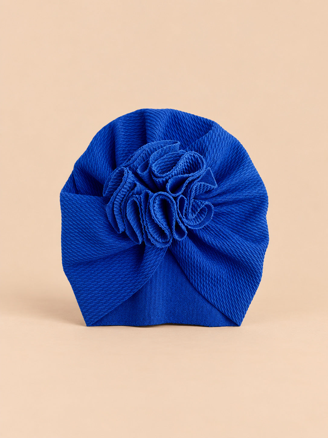 Turbante blu da neonato con fiore decorativo in tessuto sul davanti e forma morbida, vista frontale