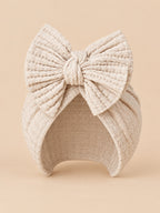 Turbante da neonata in cotone lavorato a maglia con nodo, variante beige chiaro, visto di fronte