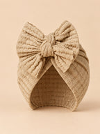 Turbante da neonata con fiocco in cotone lavorato a maglia, colori beige e sabbia, vista frontale